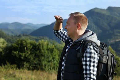 Photo of Man with backpack in beautiful mountains. Space for text