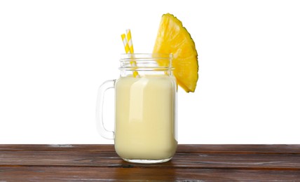 Photo of Tasty pineapple smoothie in mason jar and slice of fruit on wooden table against white background