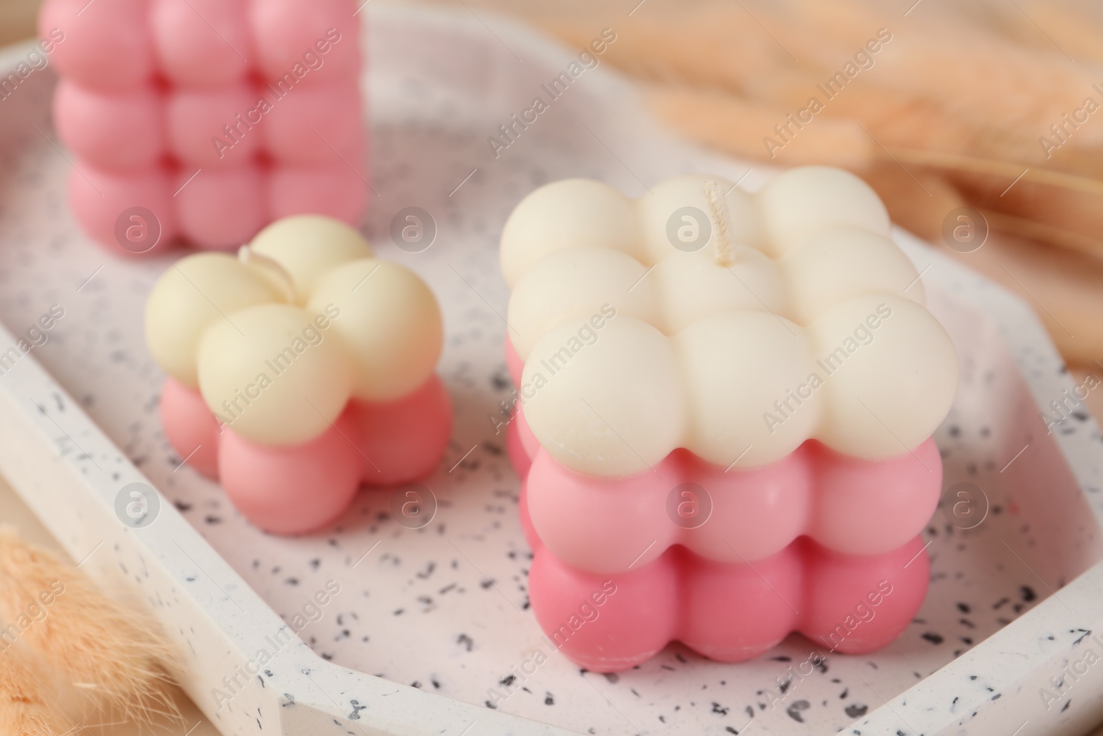 Photo of Beautiful bubble candles on tray, closeup view