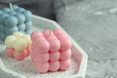 Photo of Beautiful bubble candles on grey table, closeup. Space for text