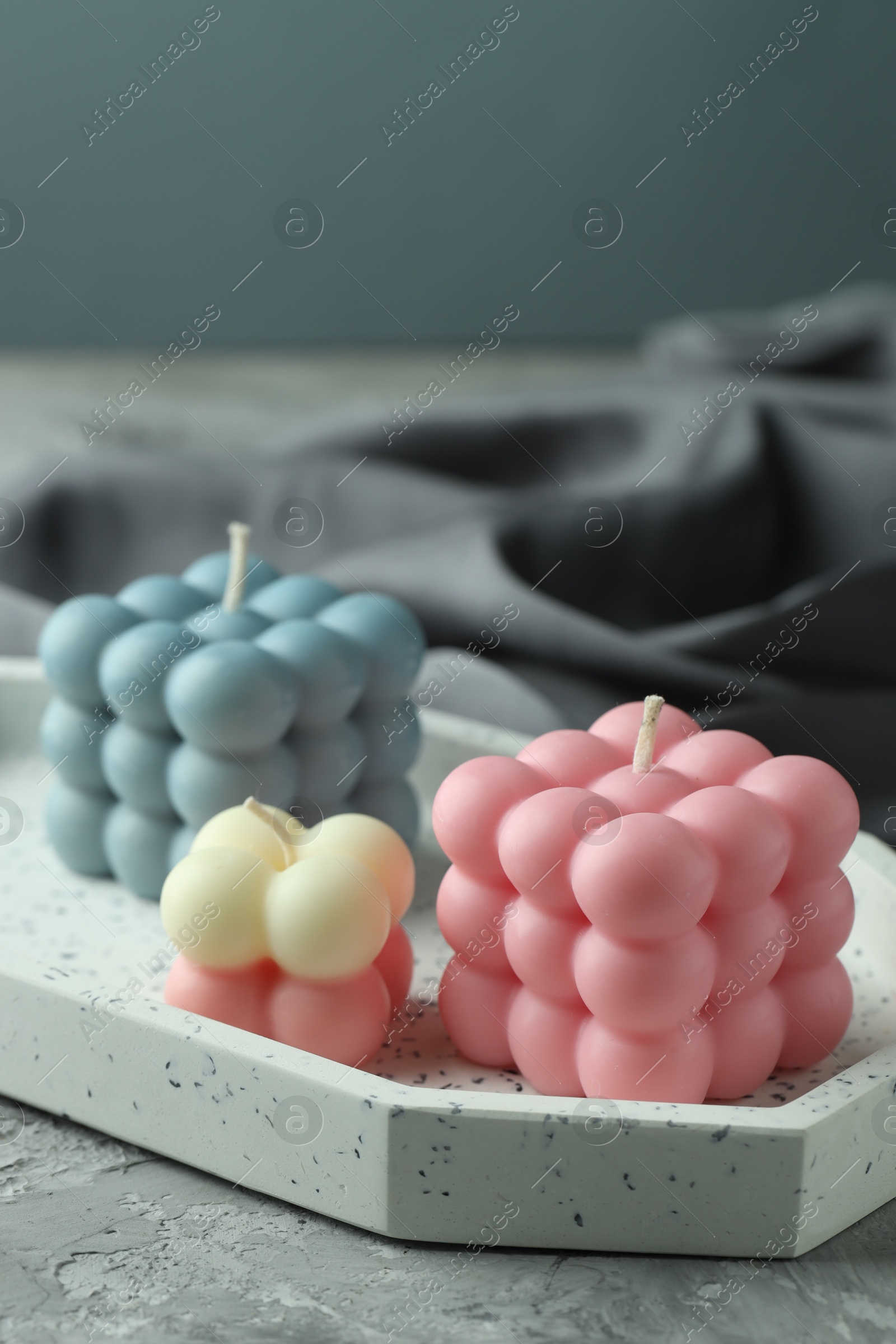 Photo of Beautiful bubble candles on grey table, closeup