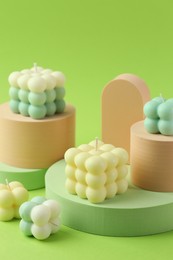 Photo of Beautiful bubble candles and geometric figures on green background