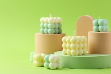 Photo of Beautiful bubble candles and geometric figures on green background