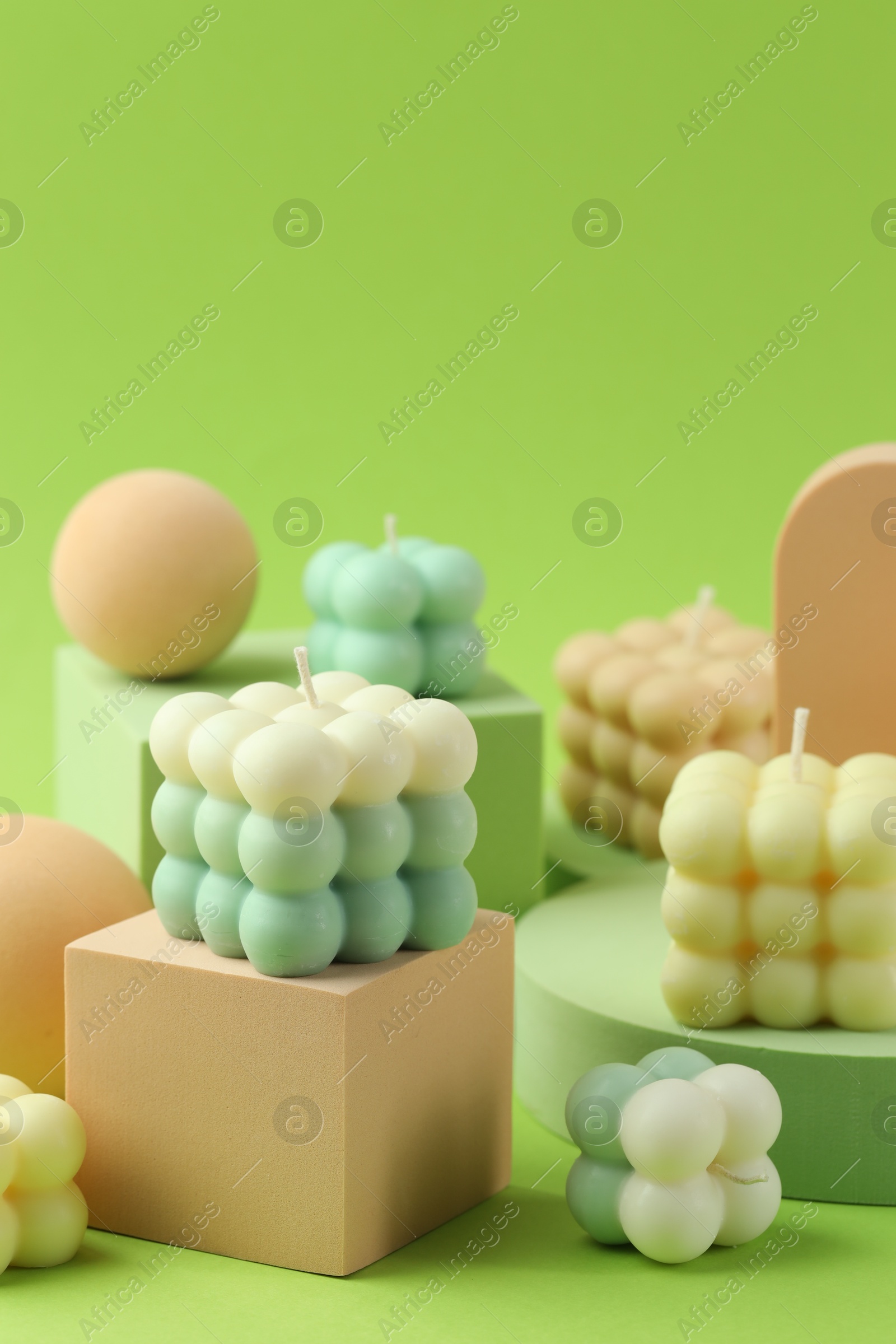 Photo of Beautiful bubble candles and geometric figures on green background