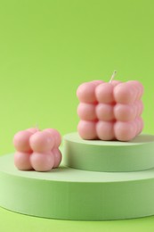 Photo of Beautiful pink bubble candles and podiums on green background