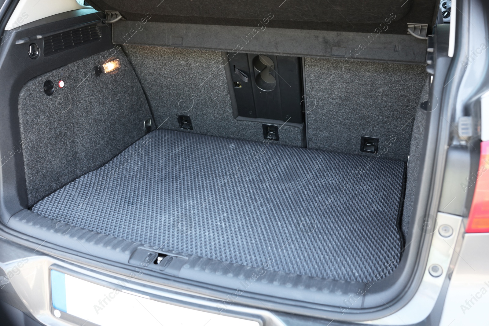 Photo of Grey rubber car boot liner mat in trunk of auto