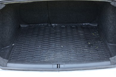 Photo of Black rubber car boot liner mat in trunk of auto