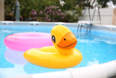 Photo of Inflatable rings floating on water in above ground swimming pool outdoors