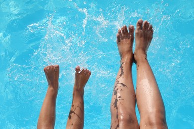 Photo of Little girl with her mother near outdoor swimming pool, top view