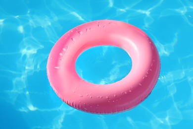 Pink inflatable ring in swimming pool outdoors