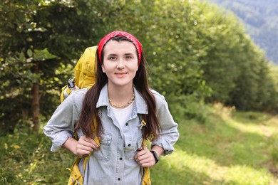 Photo of Young hiker with backpack in forest, space for text