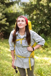 Photo of Young hiker with backpack looking at something in forest