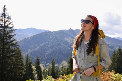 Photo of Young hiker with backpack in mountains on sunny day