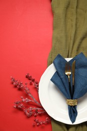 Photo of Christmas place setting with festive decor on red table, flat lay. Space for text