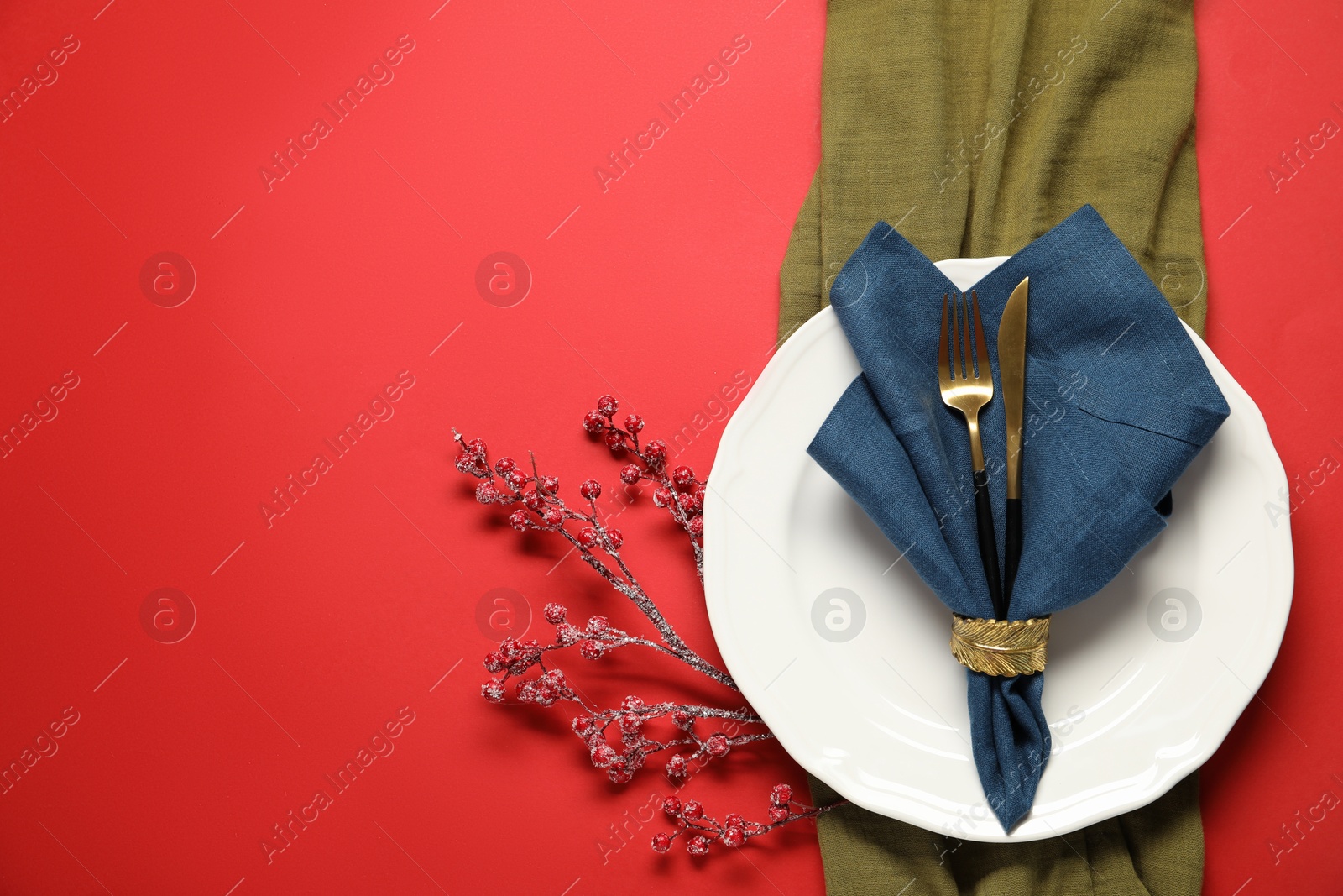 Photo of Christmas place setting with festive decor on red table, flat lay. Space for text