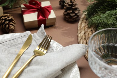 Photo of Christmas place setting with festive decor on brown table, closeup