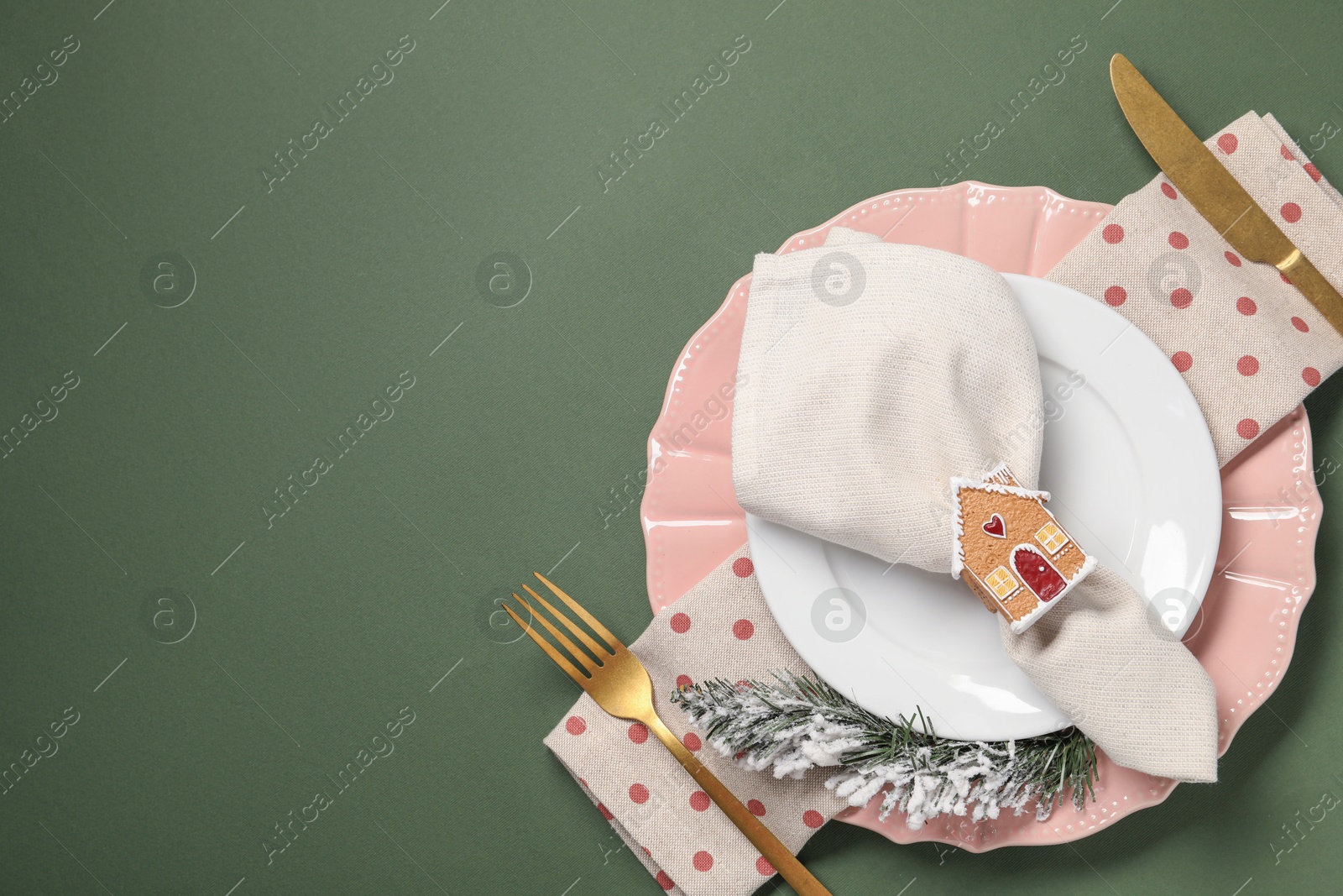 Photo of Christmas place setting and festive decor on green table, top view. Space for text