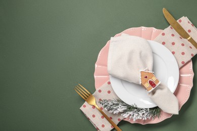 Photo of Christmas place setting and festive decor on green table, top view. Space for text