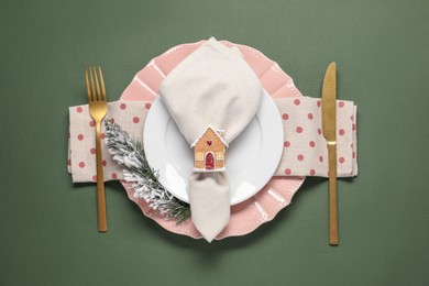 Photo of Christmas place setting and festive decor on green table, top view