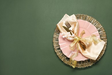 Photo of Christmas place setting and festive decor on green table, top view. Space for text