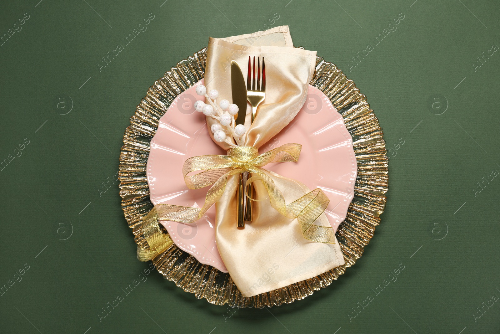 Photo of Christmas place setting and festive decor on green table, top view