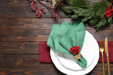 Photo of Christmas place setting with festive decor on wooden table, flat lay. Space for text