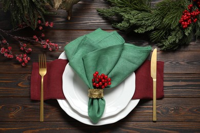 Photo of Christmas place setting with festive decor on wooden table, flat lay