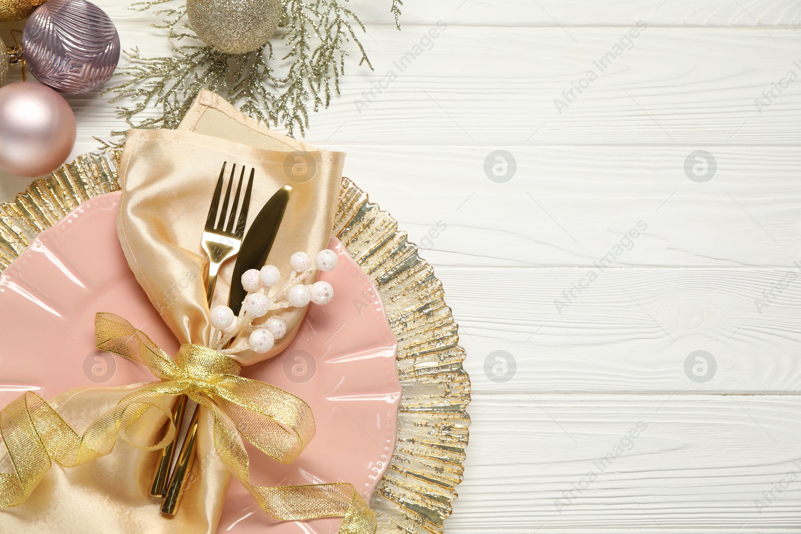 Photo of Christmas place setting with festive decor on white wooden table, flat lay. Space for text