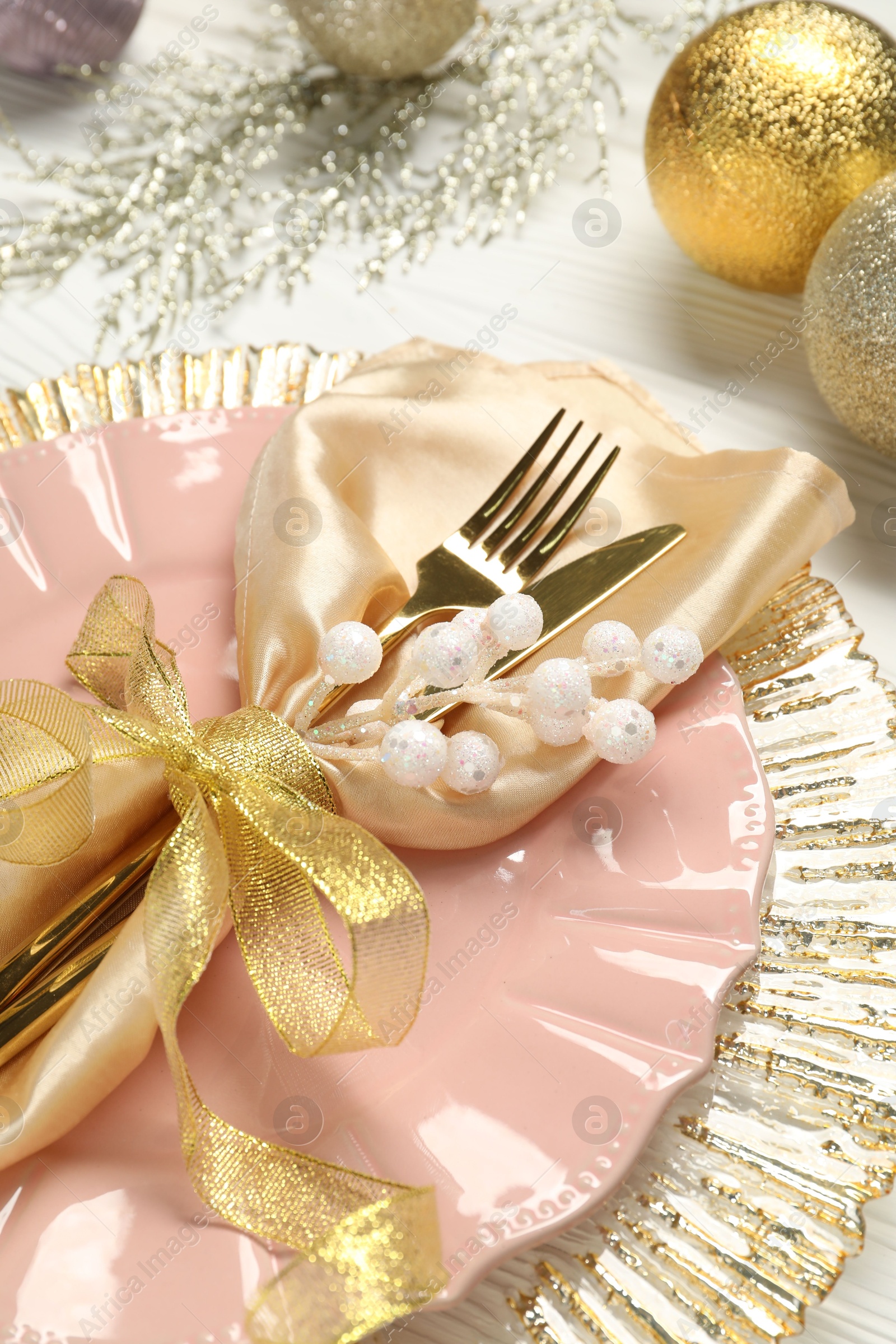 Photo of Christmas place setting with festive decor on white wooden table, closeup