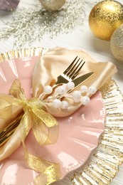 Photo of Christmas place setting with festive decor on white wooden table, closeup