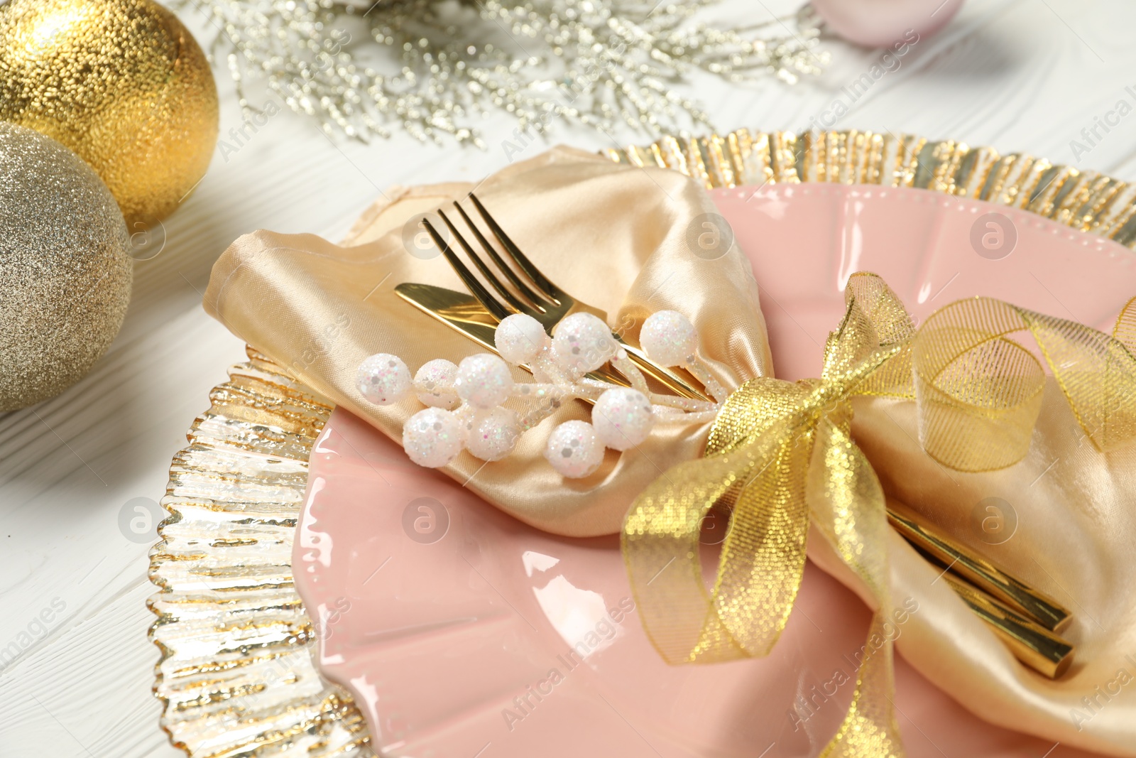 Photo of Christmas place setting with festive decor on white wooden table, closeup