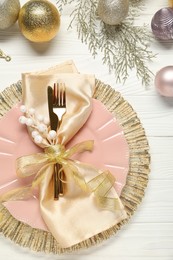 Photo of Christmas place setting with festive decor on white wooden table, flat lay