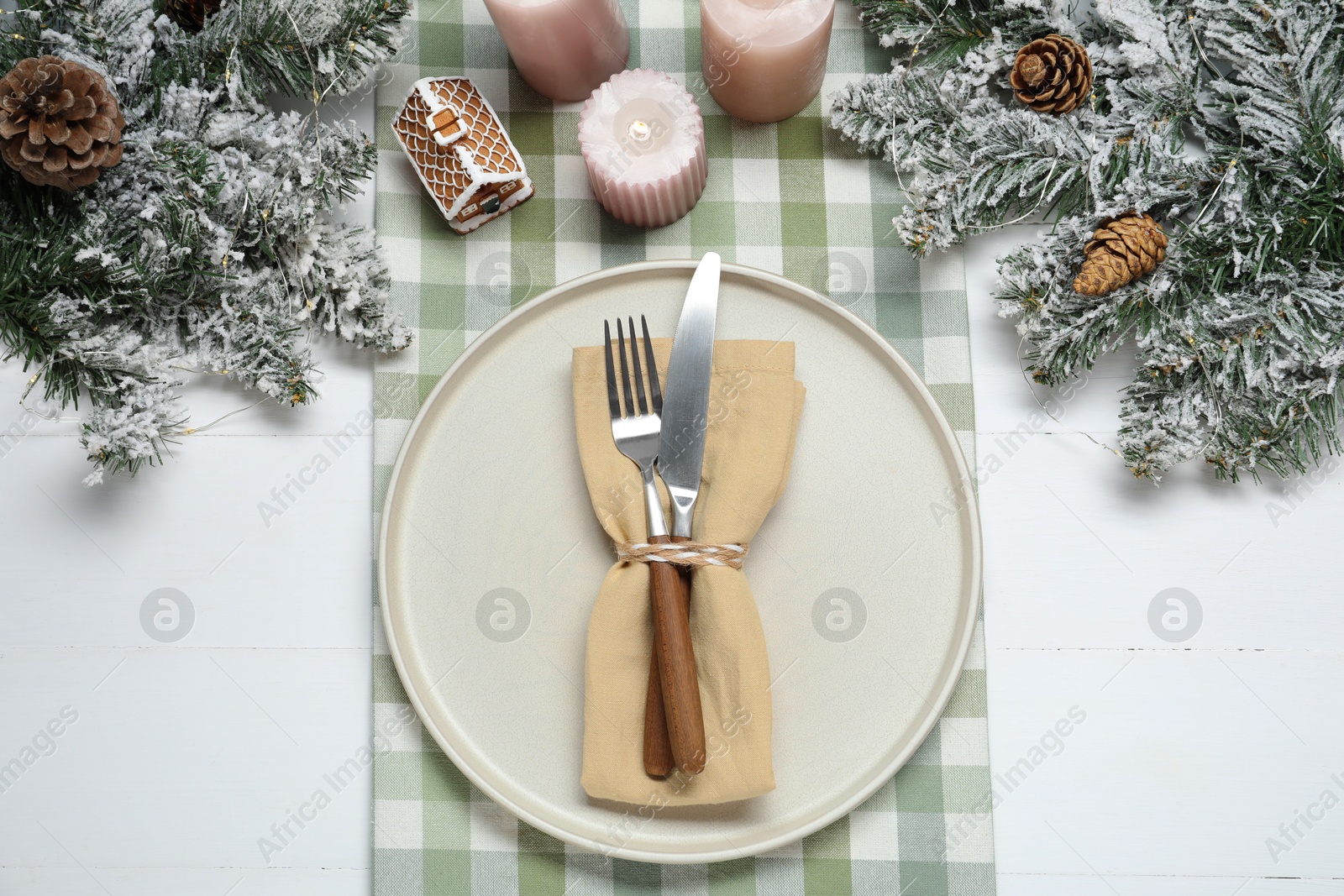 Photo of Christmas place setting with festive decor on white wooden table, flat lay