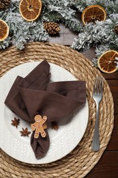 Photo of Christmas place setting with festive decor on wooden table, flat lay