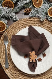 Photo of Christmas place setting with festive decor on wooden table, flat lay