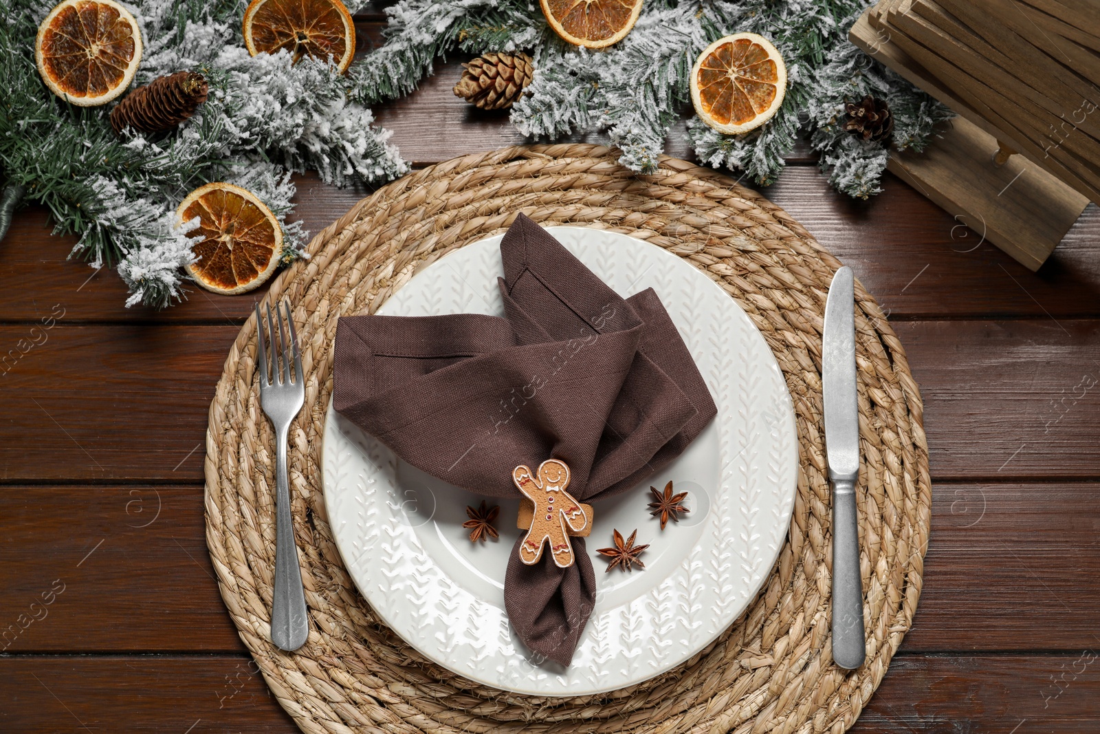 Photo of Christmas place setting with festive decor on wooden table, flat lay