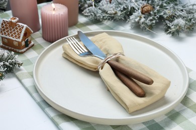 Photo of Christmas place setting with festive decor on white table, closeup