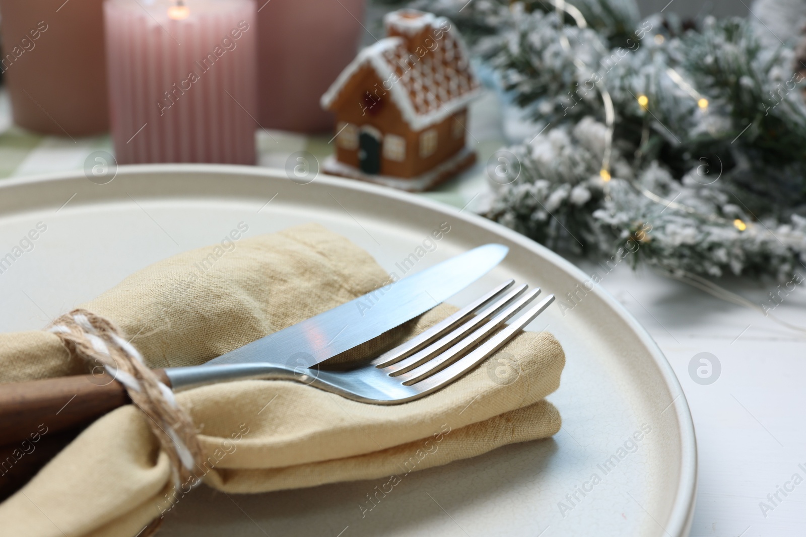 Photo of Christmas place setting with festive decor on white table, closeup