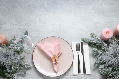 Photo of Christmas place setting with festive decor on grey textured table, flat lay. Space for text