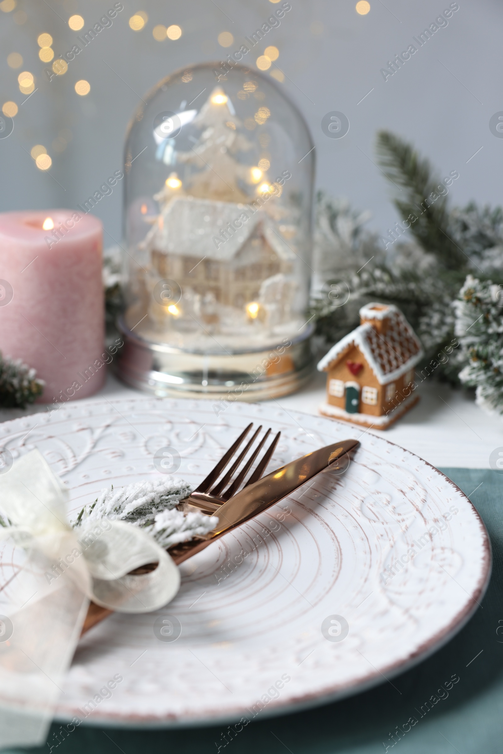 Photo of Christmas place setting with plate, cutlery and festive decor on table, closeup