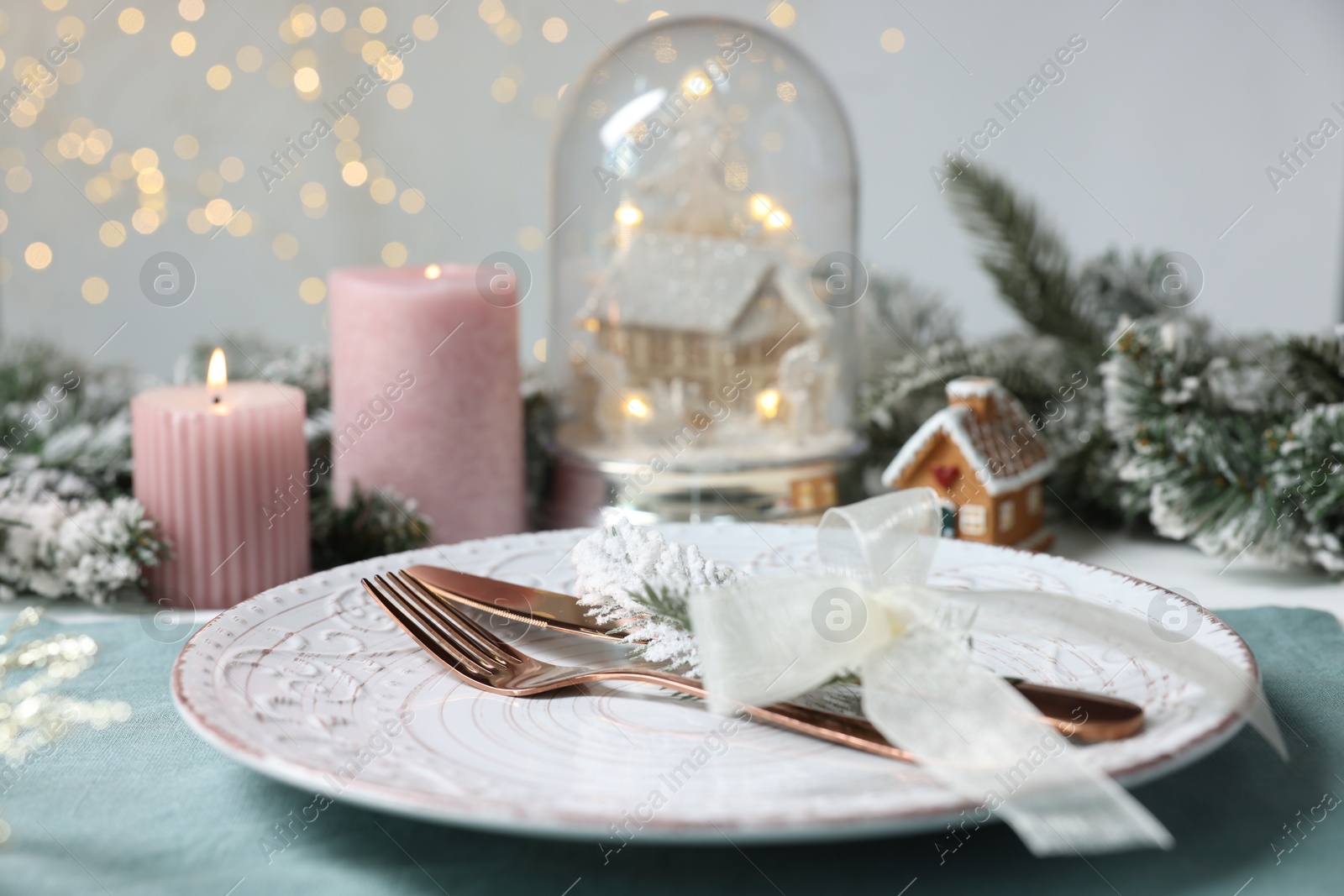 Photo of Christmas place setting with plate, cutlery and festive decor on table, closeup