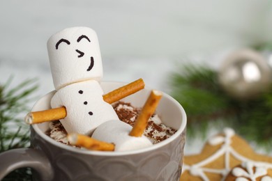 Photo of Cute marshmallow snowman in cup of hot drink, closeup