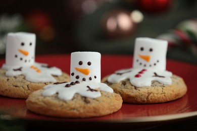 Photo of Funny marshmallow snowmen and cookies on table, closeup