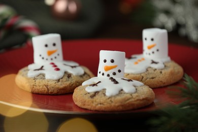 Photo of Funny marshmallow snowmen and cookies on table, closeup