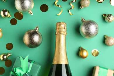 Photo of Flat lay composition with confetti and bottle of sparkling wine on green background. Christmas decor