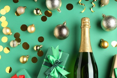 Photo of Flat lay composition with confetti and bottle of sparkling wine on green background. Christmas decor