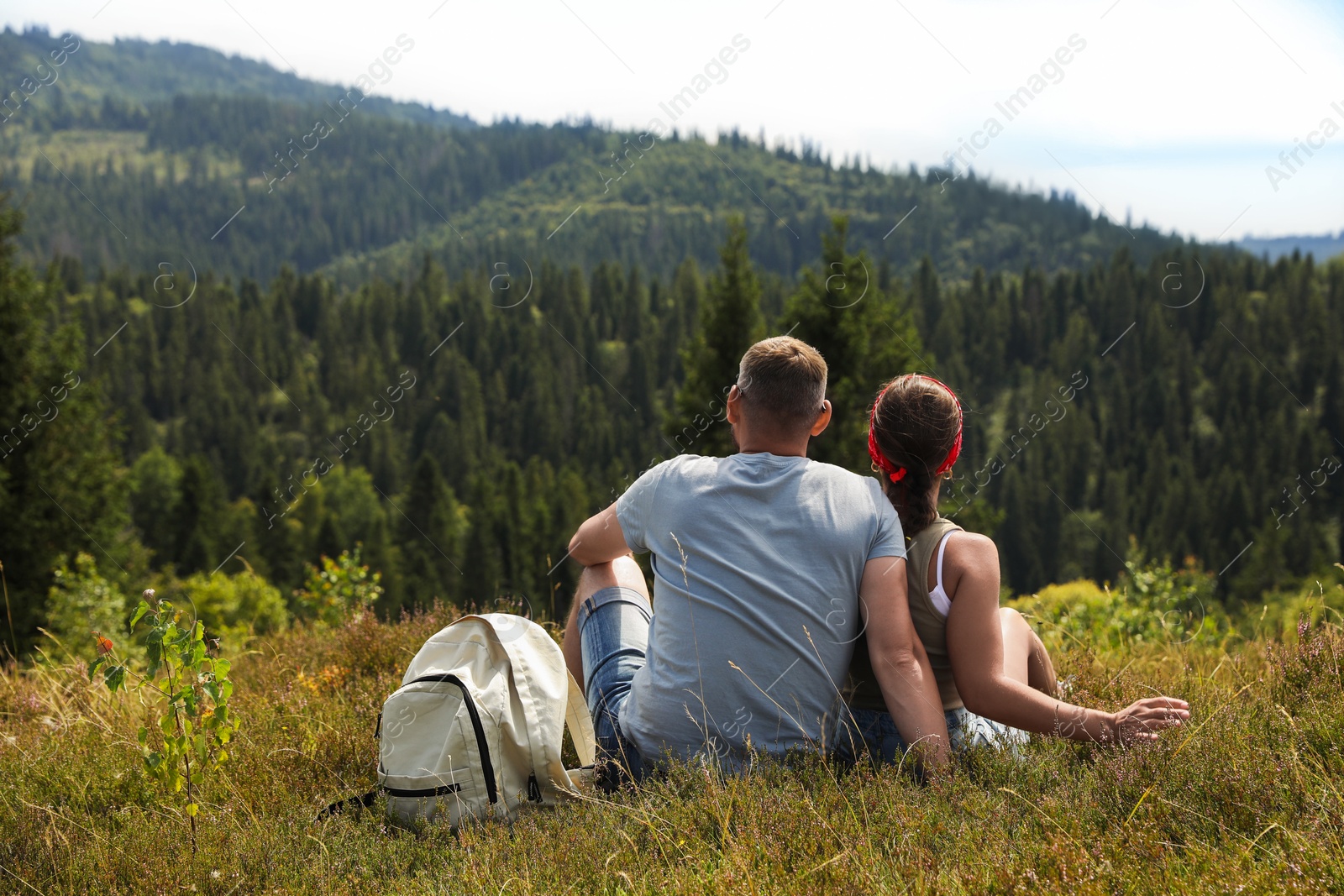 Photo of Couple with backpack enjoying picturesque landscape, back view. Active tourism