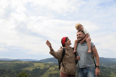 Photo of Happy family with backpacks travelling in mountains, space for text. Active tourism