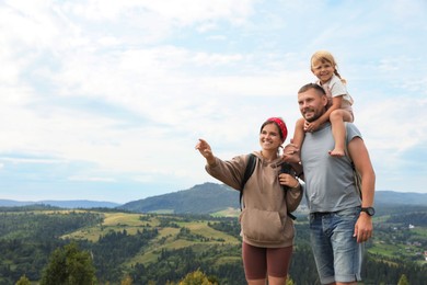 Photo of Happy family with backpacks travelling in mountains, space for text. Active tourism