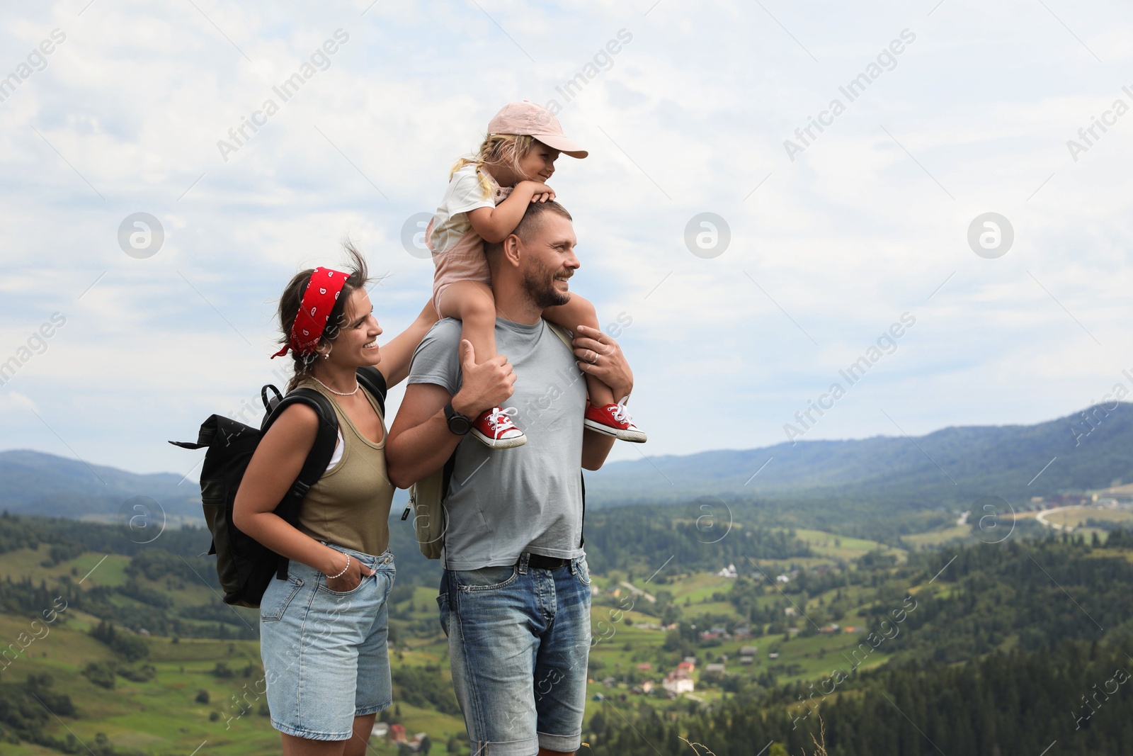 Photo of Happy family with backpacks travelling in mountains, space for text. Active tourism